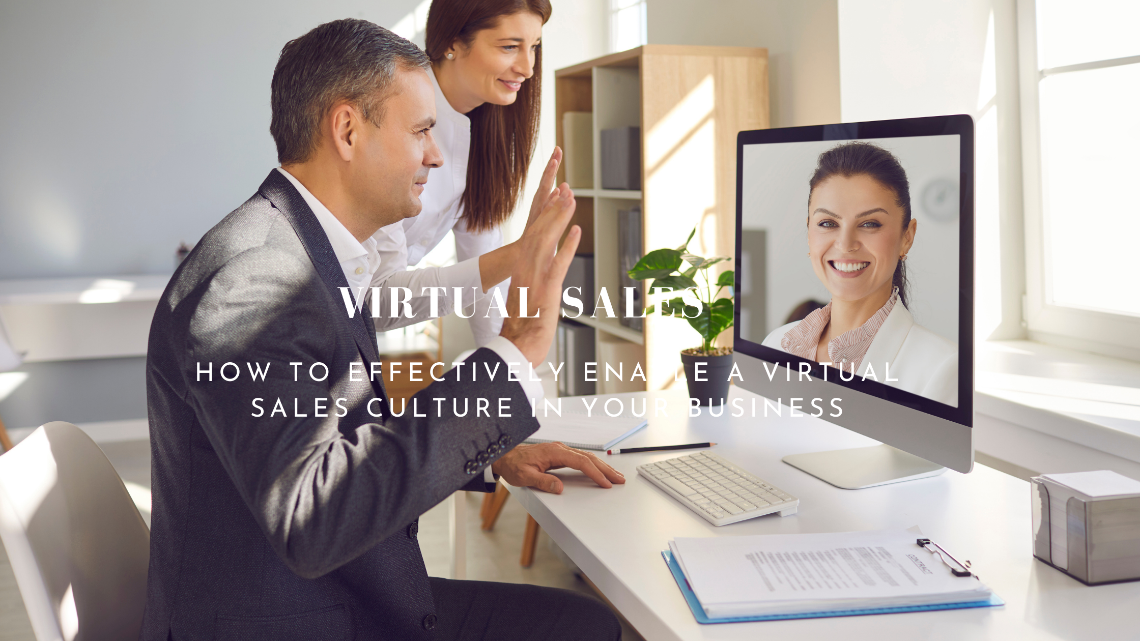 Man with raised hand up along with a women in front of a monitor with an image of a woman